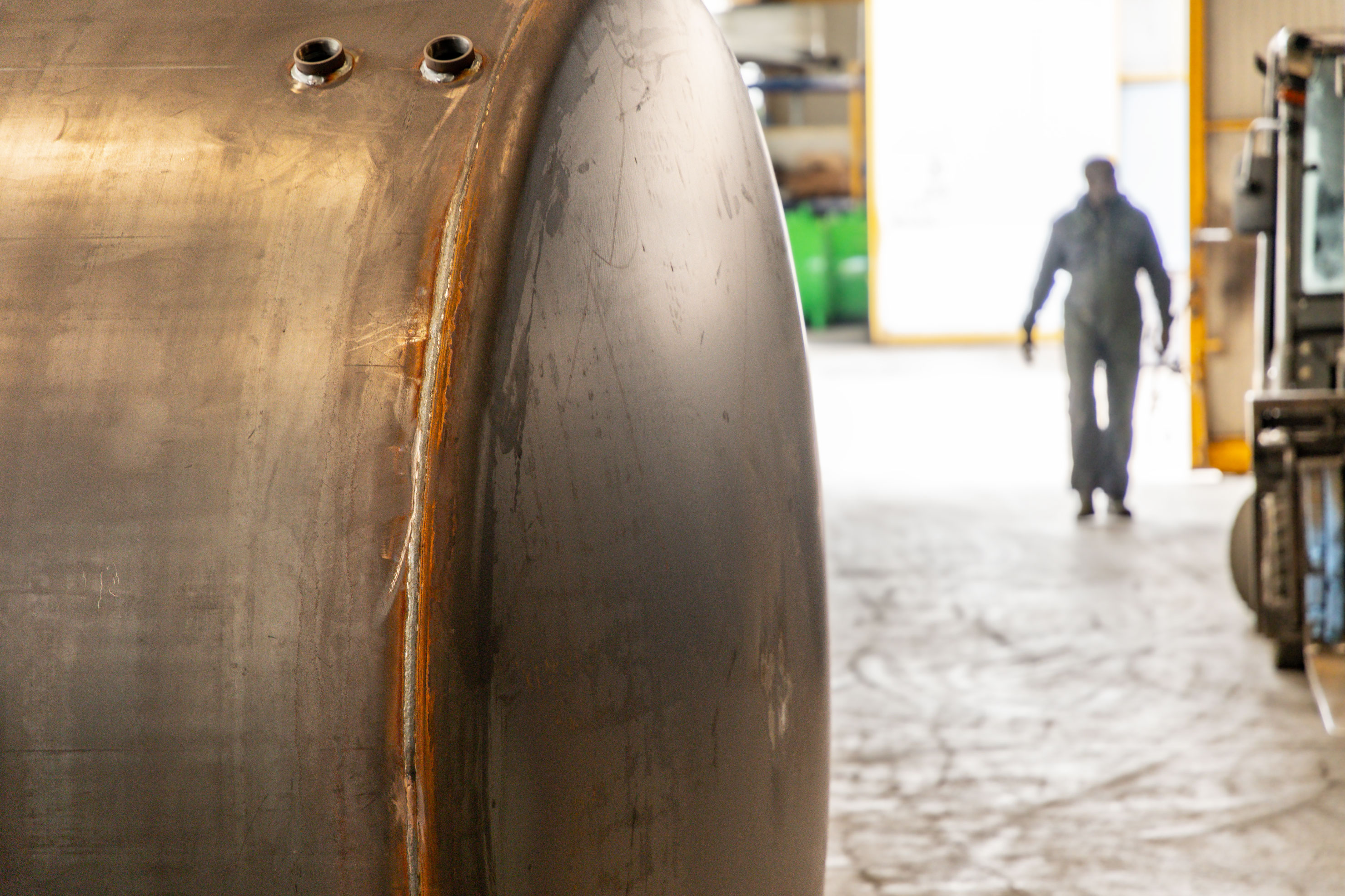 operario cammina verso serbatoio tanx da verniciare